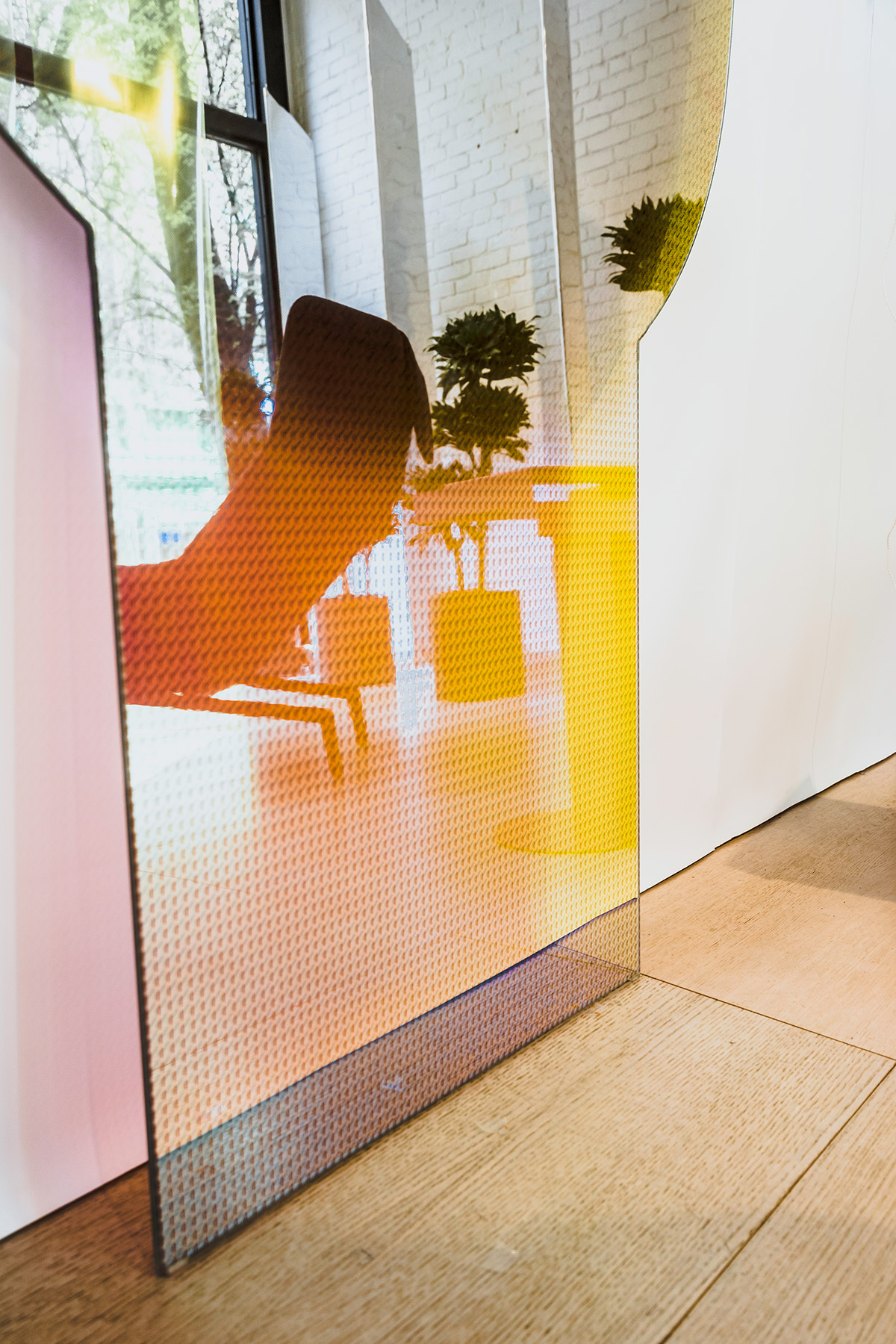 Sleek window and retail display installation at inform by Cutler, showing orange glass and reflections