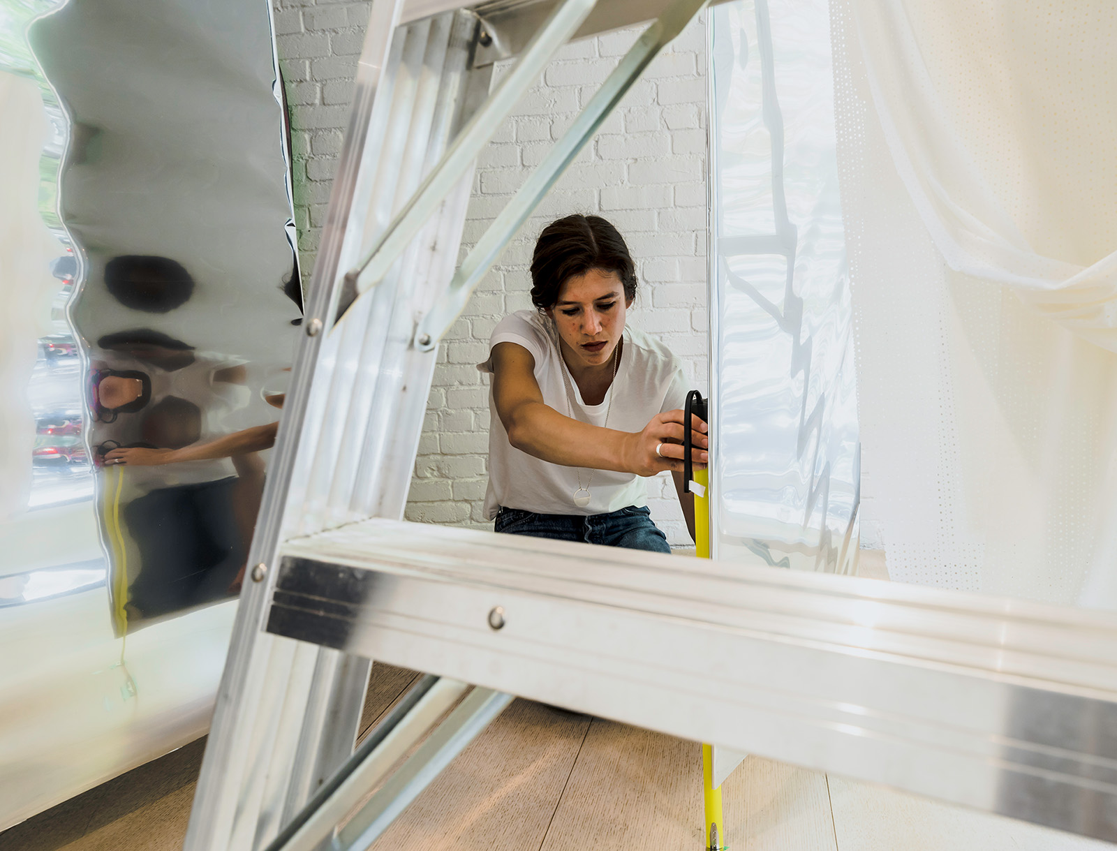 Cutler team member measuring carefully while installing Inform's window display