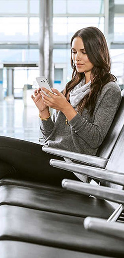 A woman in an airport using her mobile phone