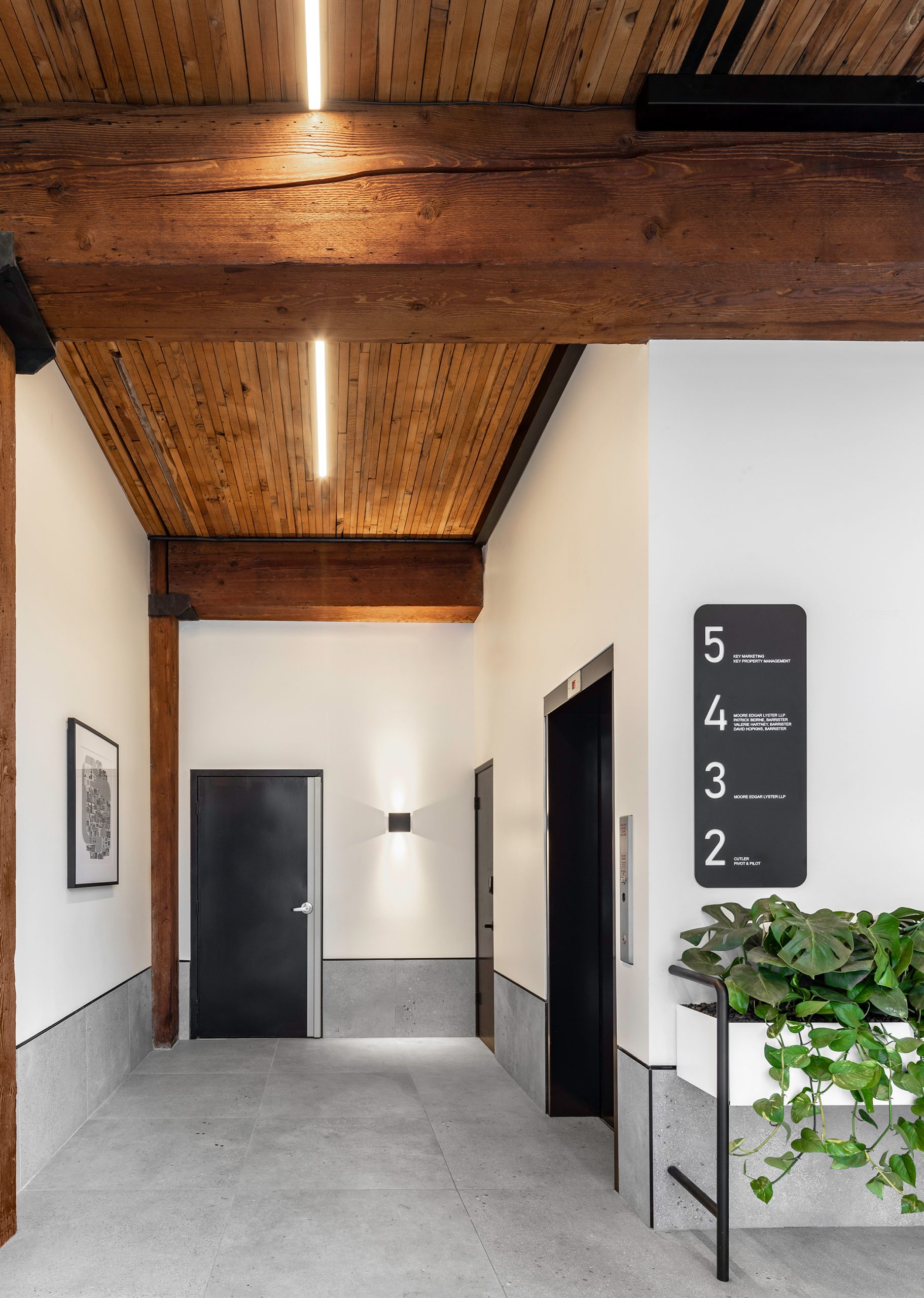 Interior office building design in Vancouver showing entry way, elevators, plants, and signage