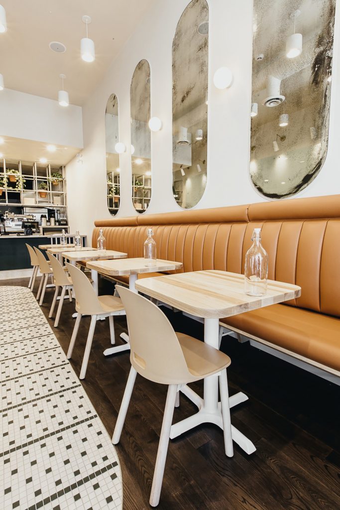 Natural materials, banquette seating and textured finishes in a Cutler-designed cafe interior