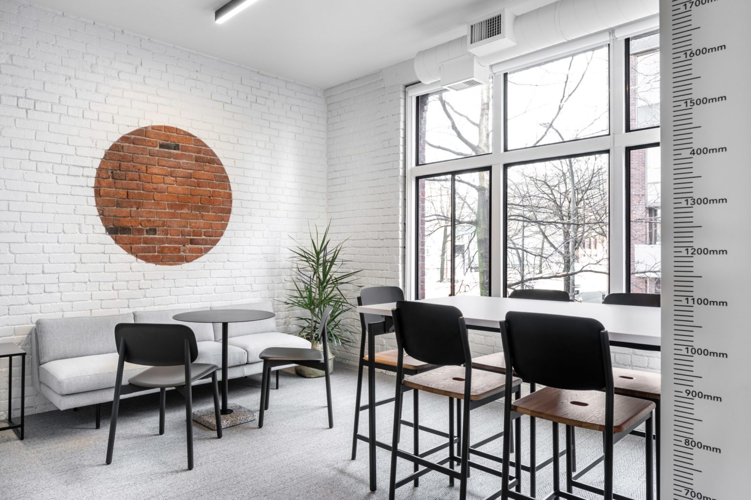 A daylit break area with lounge seating and a standing-height counter at Cutler's Vancouver studio
