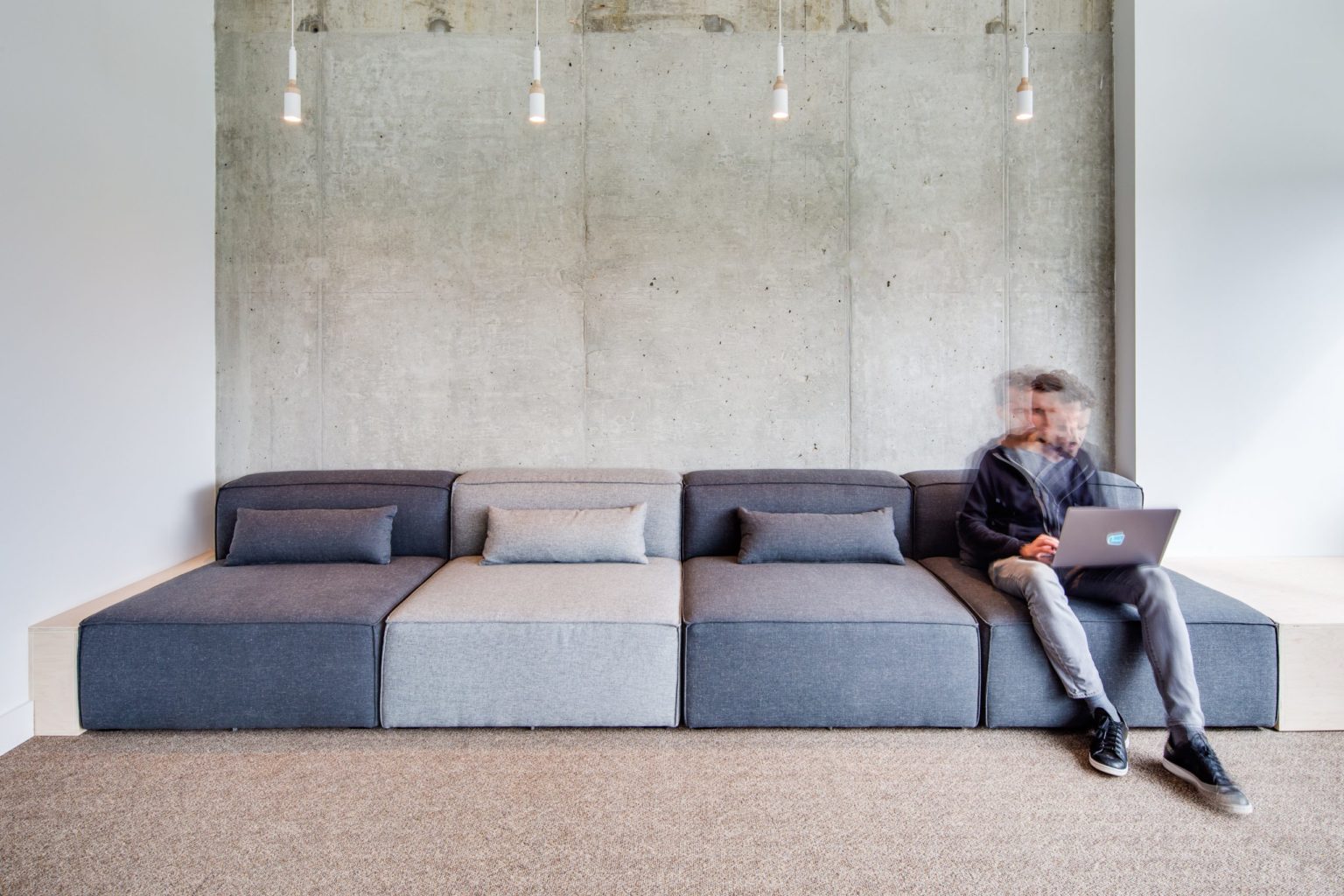 Lounge seating at Jane Software where staff can work on a laptop away from the desk, adding postural variety to the day