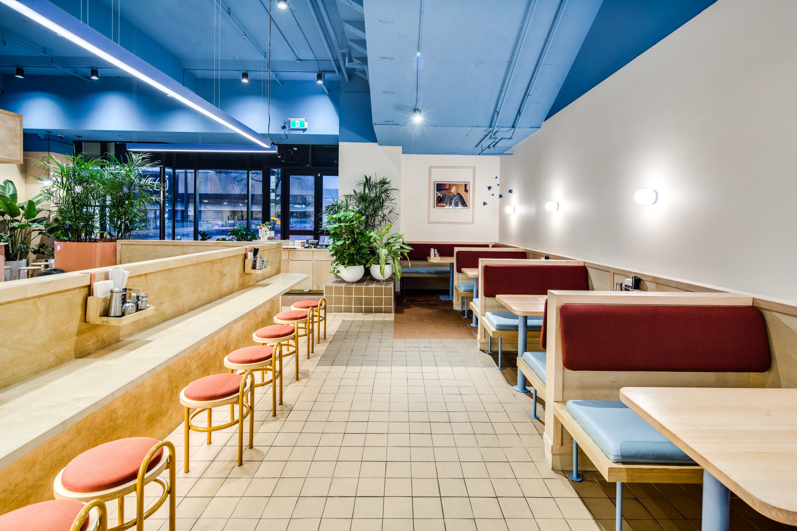 Kokoro Mazesoba restaurant interior showing customer seating, bar, white walls and blue ceiling by Cutler in Vancouver BC