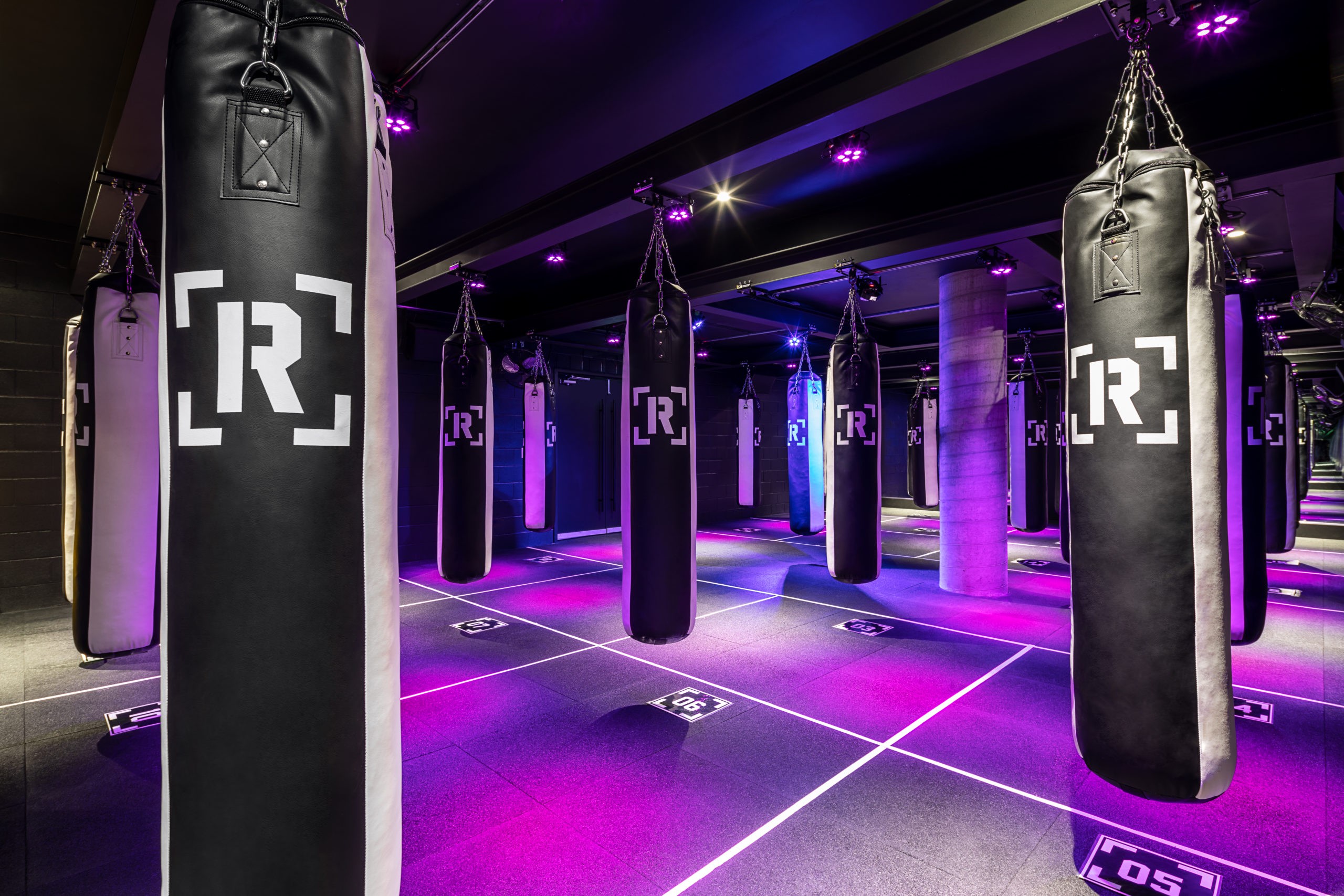 Rumble Boxing Studio in Vancouver  BC Fitness & Gym Design Gym interior design and lighting with boxing bags by Cutler