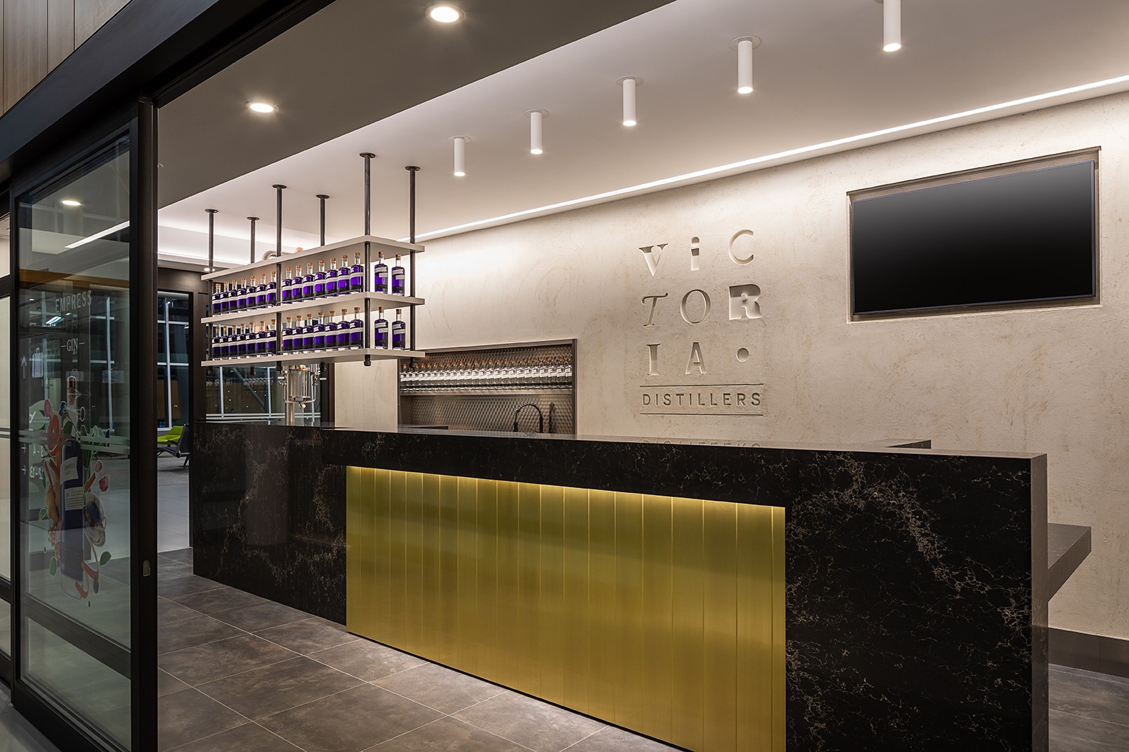 Beautiful bar design at Victoria Distillers, showing interior finish, gold accented with marble bar, by Cutler