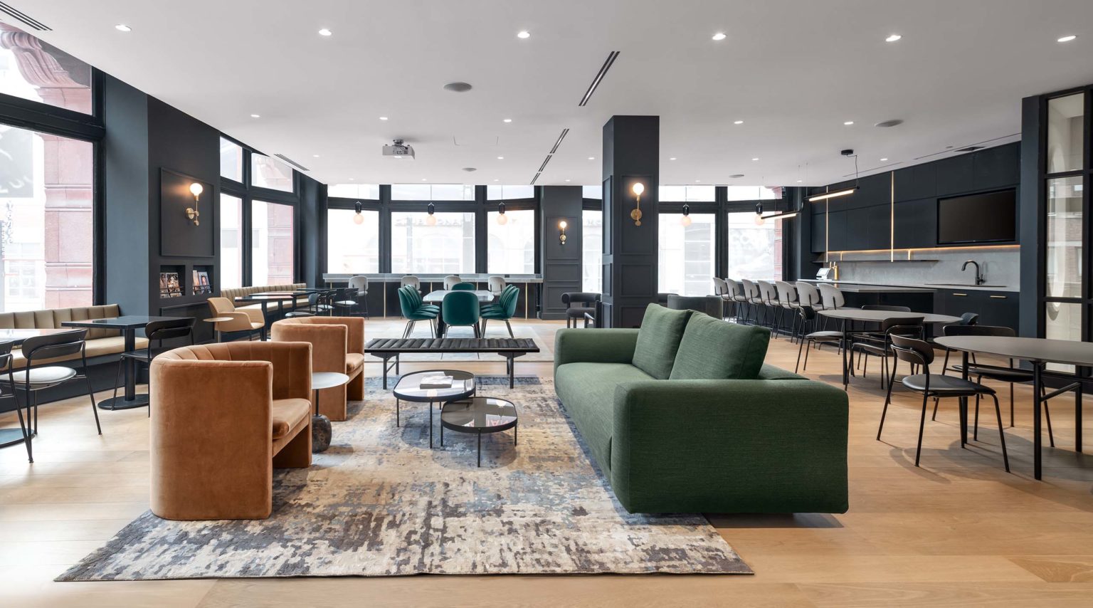 Fitness club member lounge with soft seating and communal tables, a brand-led social space designed by Cutler