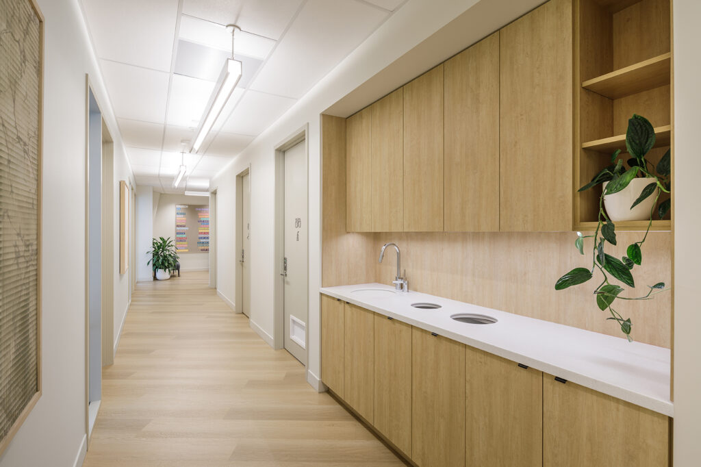 Hand hygiene sink and sealed casework positioned along the main circulation route in a Vancouver medical clinic designed by Cutler