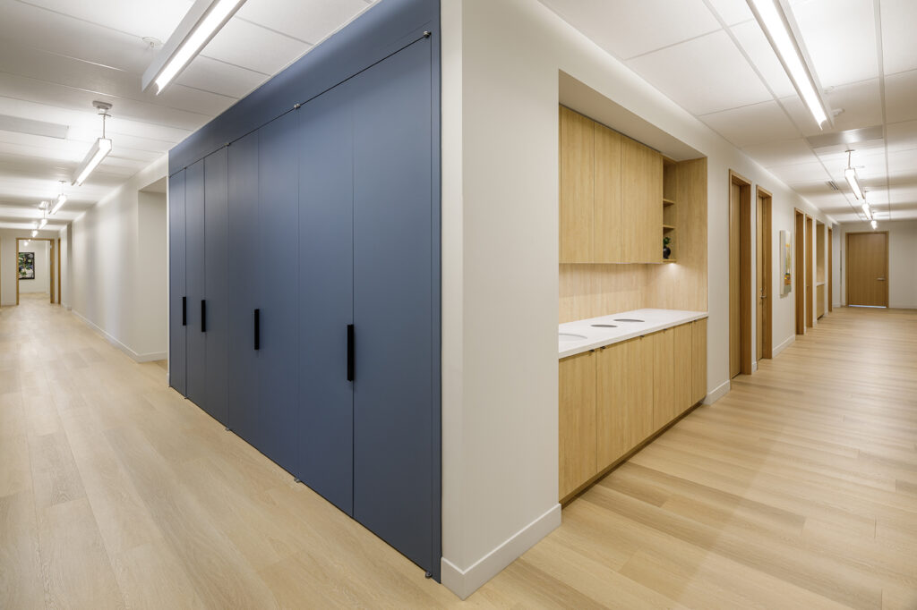 Clinical corridor with sealed millwork and seamless flooring at Harrison Healthcare, a durable healthcare interior design material palette