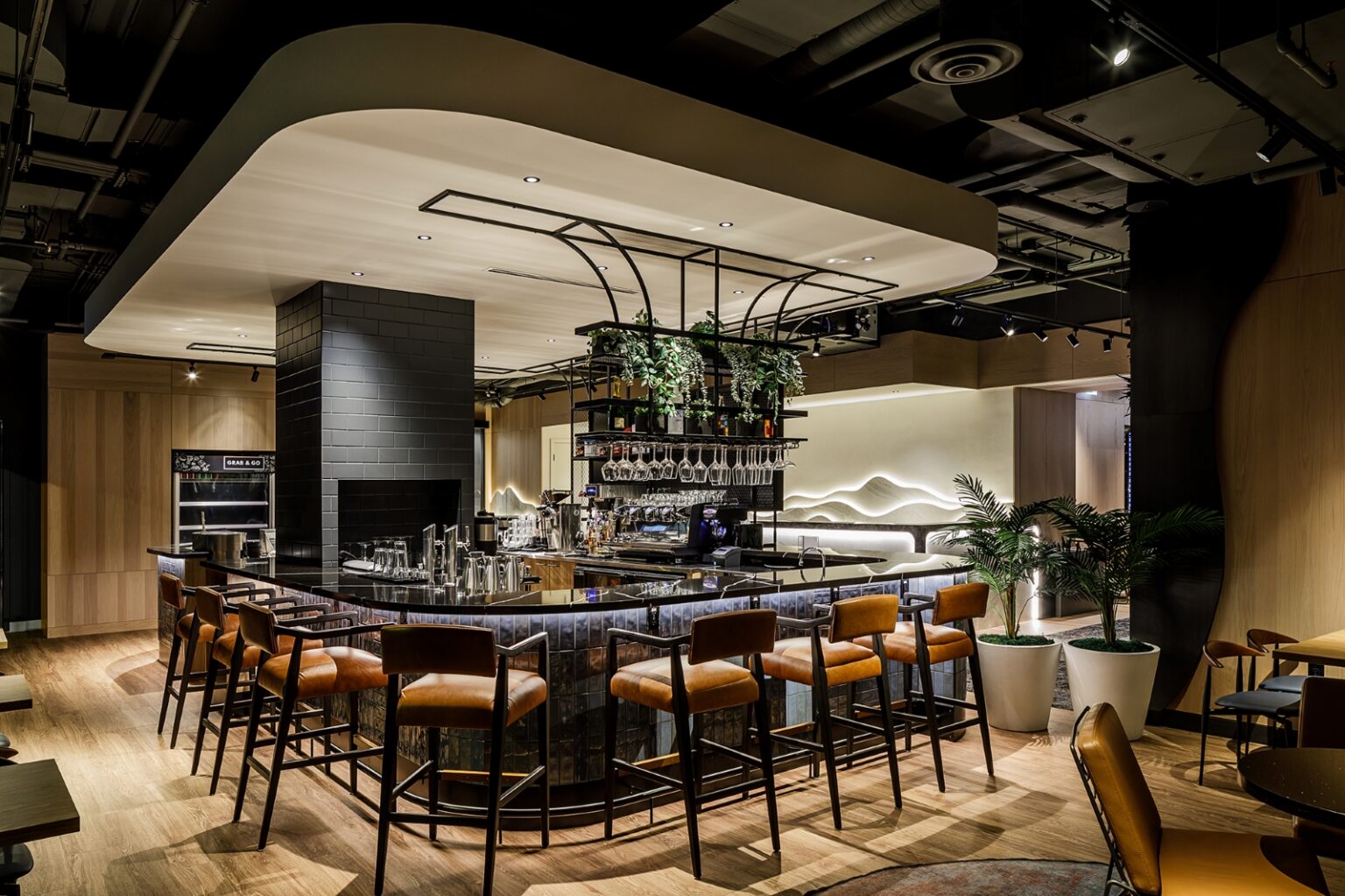 Premium fitness club lounge and juice bar with timber, planting and layered lighting designed by Cutler