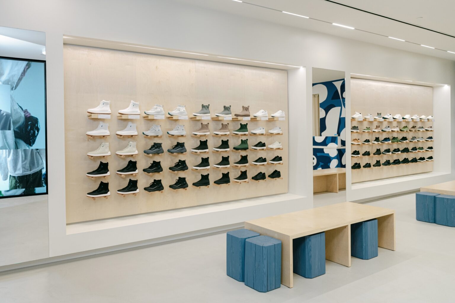 Lit footwear wall and fitting benches at the Vessi store in Square One, designed to keep customers in the store longer