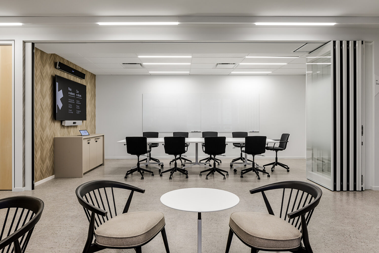 Hybrid meeting room with a wall-mounted display and rectangular table at the BDC Surrey office designed by Cutler